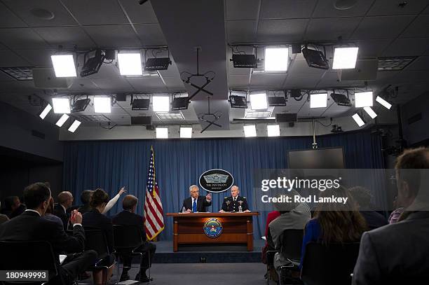 Secretary of Defense Chuck Hagel points to a reporter for a question as he and Chairman of the Joint Chiefs of Staff Gen. Martin E. Dempsey brief the...