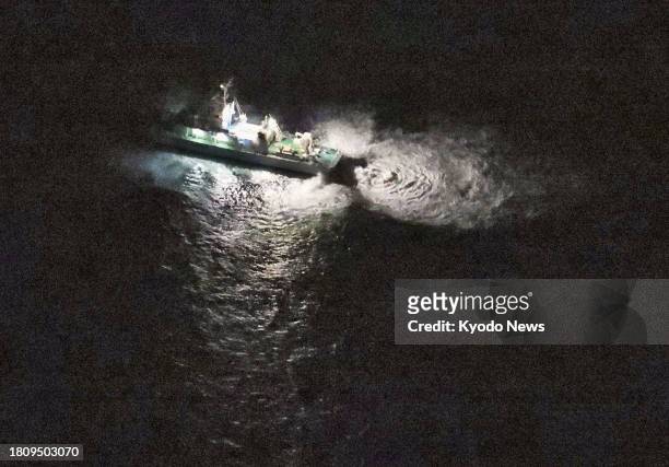 Photo taken from a Kyodo News helicopter at 6:23 p.m. On Nov. 29 shows a Japan Coast Guard ship searching around waters off Yakushima Island in...