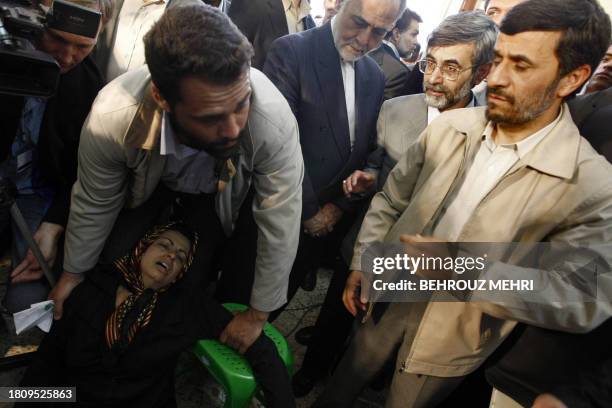 Iranian President Mahmoud Ahmadinejad , Government Spokesman Gholam Hossein Elham and First Vice President Parviz Davoodi react as a bodyguard helps...