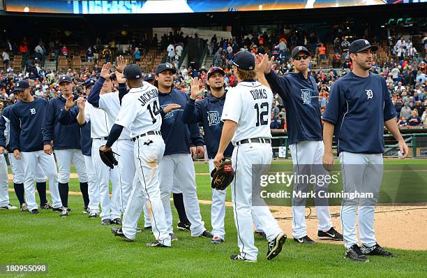 Austin Jackson and Andy Dirks of the Detroit Tigers get high-fives from teammates after the victory against the Kansas City Royals at Comerica Park...