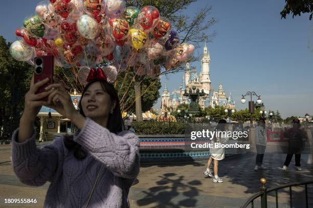 Visitor takes a selfie photograph at Walt Disney Co.'s Shanghai Disneyland Resort in Shanghai, China, on Wednesday, Nov. 29, 2023. Walt Disney is set...