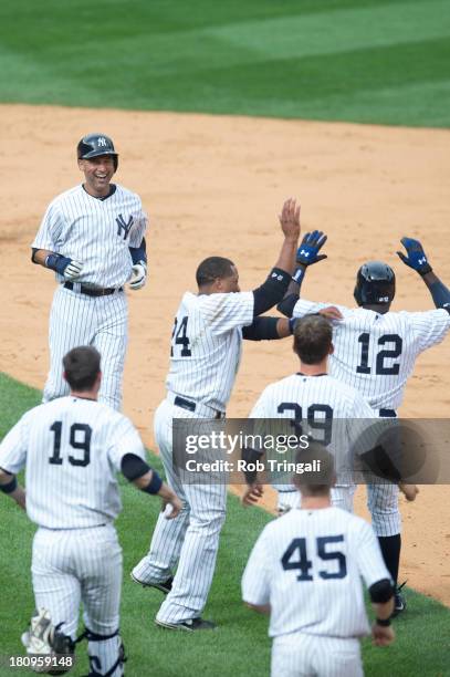 Alfonso Soriano of the New York Yankees celebrates with Robinson Cano and Derek Jeter after hitting a game winning base hit against the Tampa Bay...
