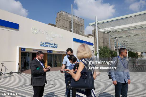 Attendees outside the entrance to the Blue Zone ahead of the COP28 climate conference at Expo City in Dubai, United Arab Emirates, on Wednesday, Nov....