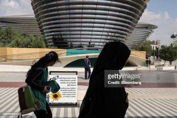 Attendees pass the Alif mobility pavilion in the Green Zone ahead of the COP28 climate conference at Expo City in Dubai, United Arab Emirates, on...