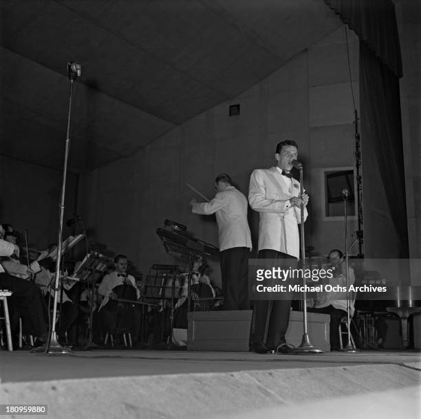 Pop singer Frank Sinatra performs onstage with Max Steiner conducting the orchestra at Lewisohn Stadium on August 3, 1943 in New York City, New York.