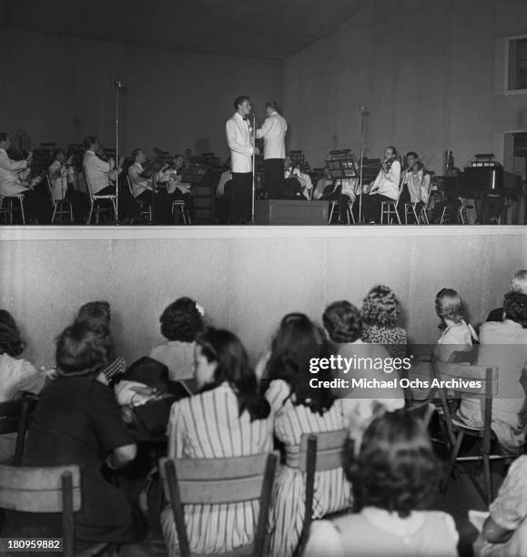 Pop singer Frank Sinatra performs onstage with Max Steiner conducting the orchestra at Lewisohn Stadium on August 3, 1943 in New York City, New York.