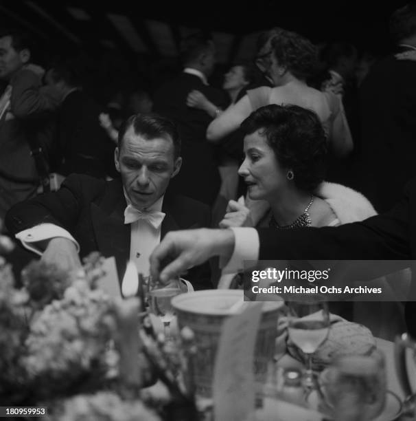 Singer and actor Frank Sinatra attends the 27th Academy Awards dinner with actress Merle Oberon on March 30, 1955 in Los Angeles, California.