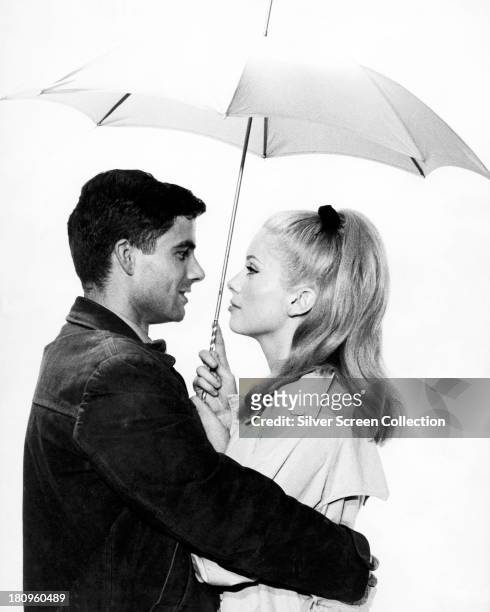 French actress Catherine Deneuve and Italian actor Nino Castelnuovo in a promotional portrait for 'The Umbrellas Of Cherbourg' , directed by Jacques...