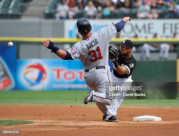 Oswaldo Arcia of the Minnesota Twins attempts to steal second base and is tagged out by Leury Garcia of the Chicago White Sox during the first inning...