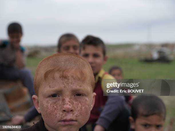 Peti garçon aux cheveux roux au milieu de d'autres enfants le 28 mars 2017 à Mossoul.