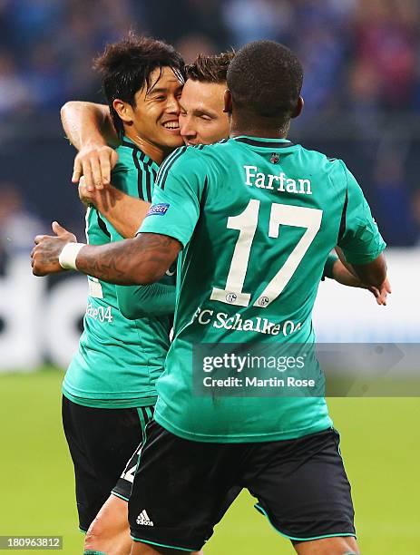 Atsuto Uchida of Schalke celebrates scoring the opening goal with team mates during the UEFA Champions League Group E match between FC Schalke 04 and...