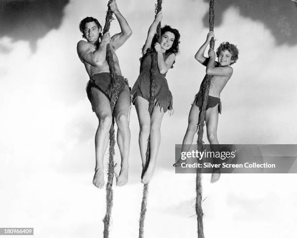 Johnny Weissmuller as Tarzan, Maureen O'Sullivan as Jane Parker, and Johnny Sheffield , as Boy, swinging on vines in a promotional still for...