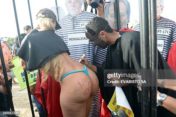 Protesters fancy dressed as the president of Brazil's Supreme Court Joaquim Barbosa and popular singer "Bandida" take part in a protest against the...