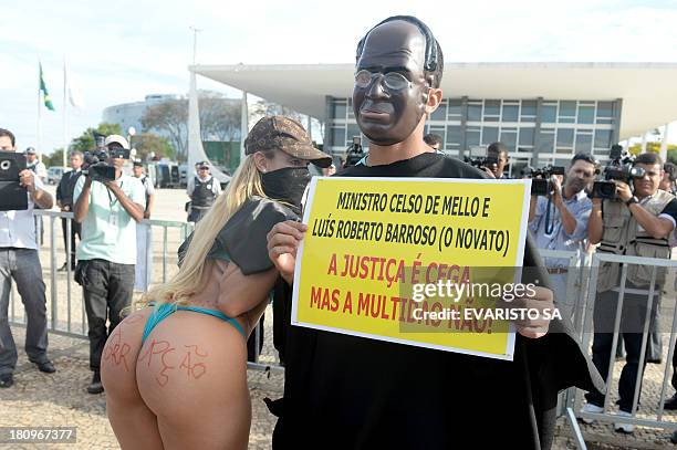 Protesters fancy dressed as the president of Brazil's Supreme Court Joaquim Barbosa and popular singer "Bandida" take part in a protest against the...