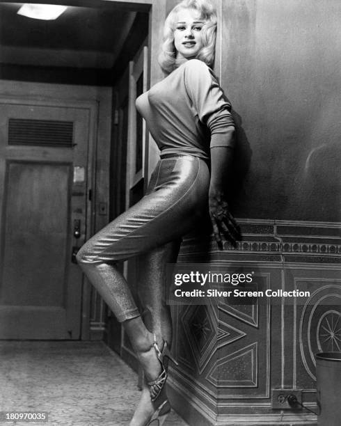 English actress and glamour model Sabrina wearing lurex trousers and a tight sweater, circa 1957.