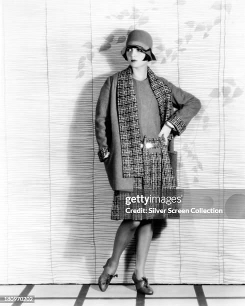 American actress Louise Brooks wearing a plaid coat, skirt and cloche hat, circa 1927.