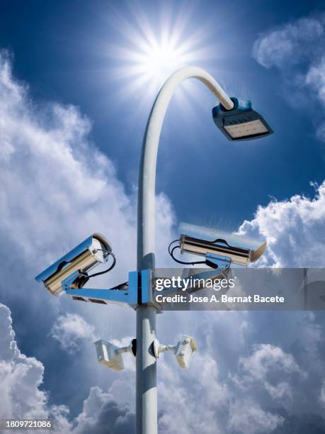 security and surveillance camera on a led street lamp on a blue sky. - led street light stock pictures, royalty-free photos & images