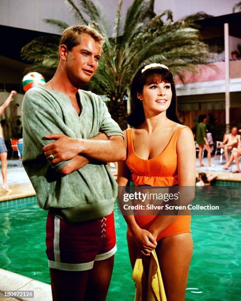 American actors Troy Donahue , as Jim Munroe, and Stefanie Powers as Bunny Dixon, standing by a swimming pool in a promotional portrait for 'Palm...