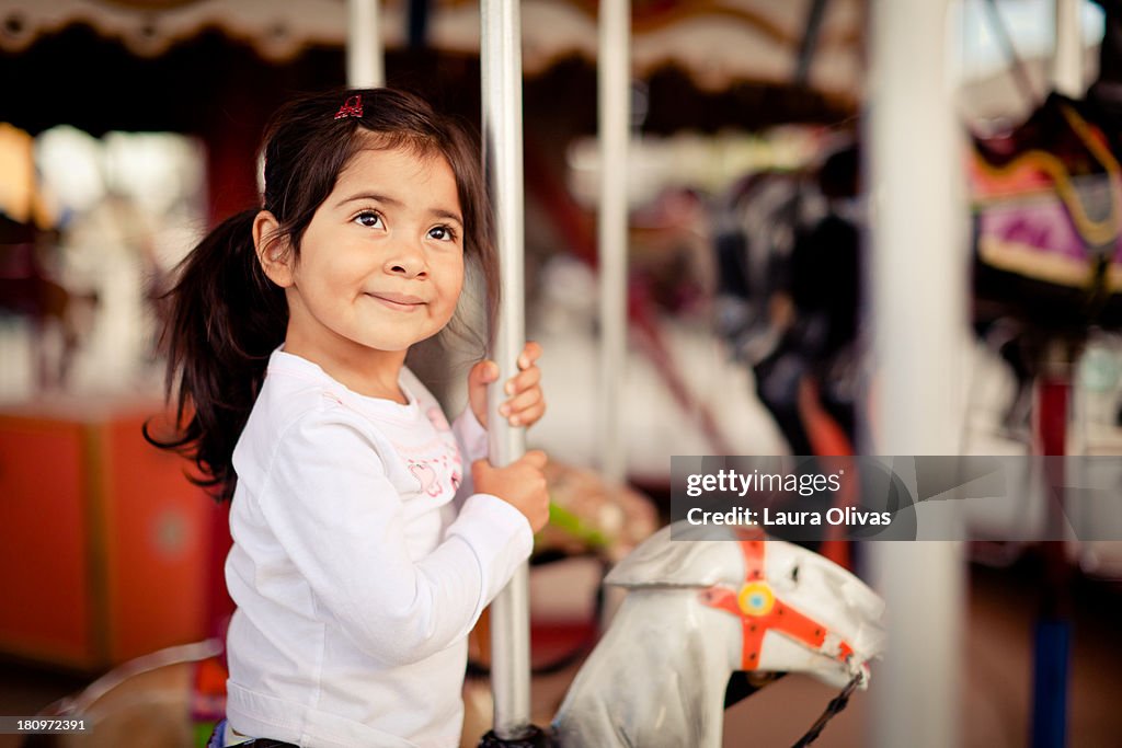 Girl Smiling On Merry-Go-Round