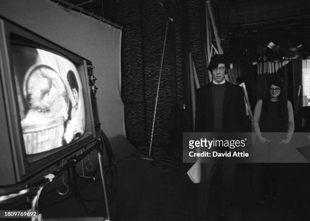 Two crew members watch actress Loretta Long talk to Oscar the Grouch on a TV monitor during the taping of Sesame Street's very first season, taken...