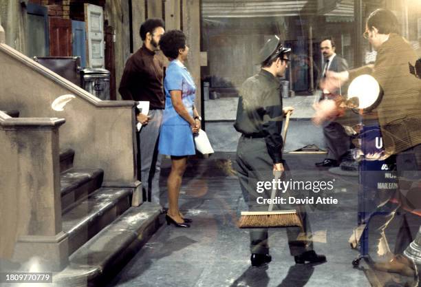 Photo montage of actress Loretta Long , actor Matt Robinson , and a street-cleaner character superimposed over puppeteers Daniel Seagren and Caroly...