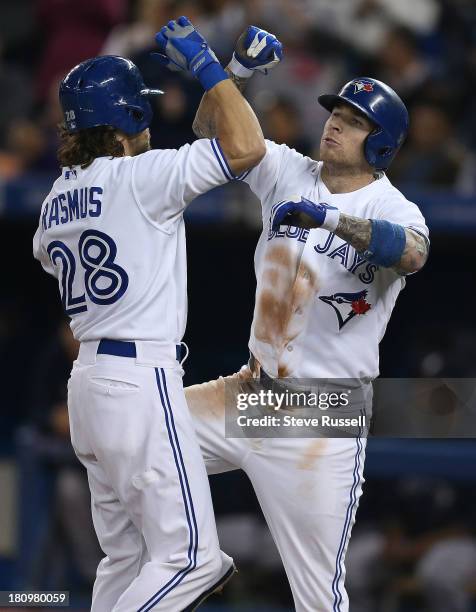 Brett Lawrie helps Colby Rasmus celebrate his two-run homer as the Toronto Blue Jays lose to the New York Yankees 4-3 at Rogers Centre in Toronto,...