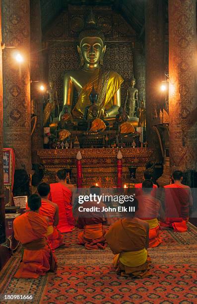 buddha and monks inside wat xieng thong - wat imagens e fotografias de stock