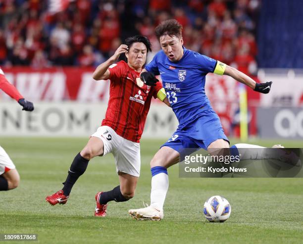 Japan's Urawa Reds midfielder Ken Iwao vies for the ball with a Wuhan Three Towns opponent during the first half of a match in the Asian Champions...