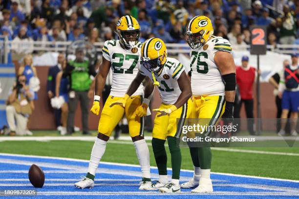 Jayden Reed of the Green Bay Packers celebrates with teammates Patrick Taylor and Jon Runyan after scoring a touchdown against the Detroit Lions...