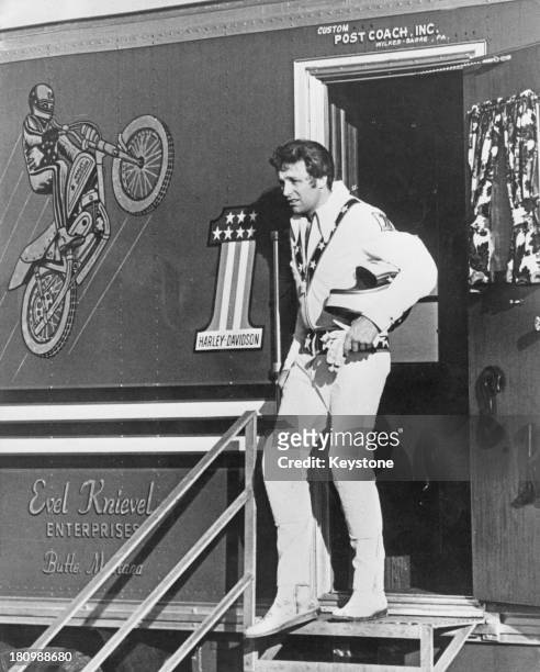 American stunt person Evel Knievel stands in the doorway of his official custom built coach he uses for touring, circa 1972.