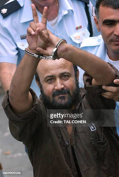 Hand cuffed and flashing the 'V'-sign, Marwan Barghuti the leader of Yasser Arafat's Fatah movement in the West Bank is flanked by Israeli policemen...
