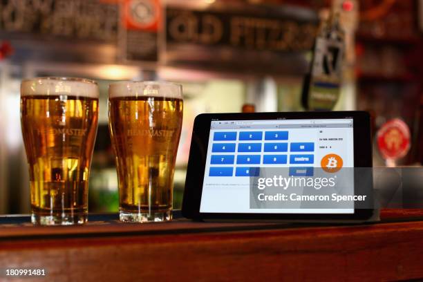 In this photo illustration, a terminal to accept payments using bitcoins is displayed on the bar at the Old Fitzroy pub on September 19, 2013 in...