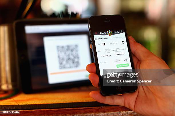 In this photo illustration, a customer pays for drinks at the Old Fitzroy Pub using bitcoins on September 19, 2013 in Sydney, Australia. The Old...