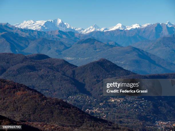 view of monte rosa and ticino pre-alps or ceresio pre-alps from monte san giorgio - lepontinische alpen stock-fotos und bilder