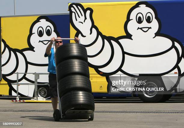 Mechanics of Renault team carries Michelin wheels, after the polemical Grand Prix at Indianapolis, during a training session at Jerez racetrack, 23...