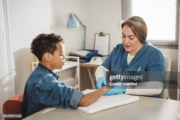 child with arm injury at doctors office - elbow bandage stock pictures, royalty-free photos & images
