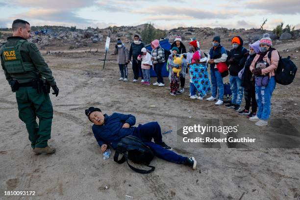 Jacumba, CA, Friday, November 24, 2023 - An apparently ill Chinese man collapses in front of a U.S. Border Patrol agent at a makeshift refugee camp...