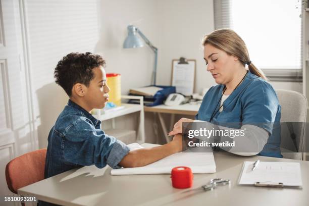 child with arm injury at doctors office - elbow bandage stock pictures, royalty-free photos & images