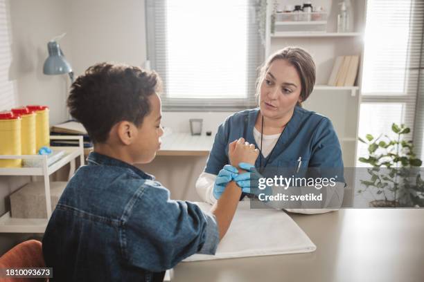 child with arm injury at doctors office - elbow bandage stock pictures, royalty-free photos & images