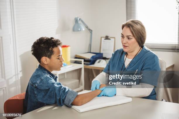 child with arm injury at doctors office - elbow bandage stock pictures, royalty-free photos & images