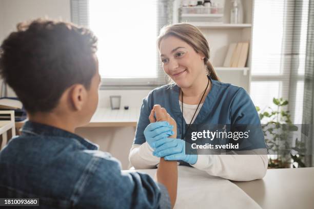 child with arm injury at doctors office - elbow bandage stock pictures, royalty-free photos & images