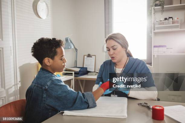 child with arm injury at doctors office - elbow bandage stock pictures, royalty-free photos & images