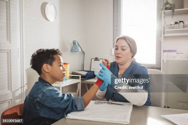 child with arm injury at doctors office - elbow bandage stock pictures, royalty-free photos & images