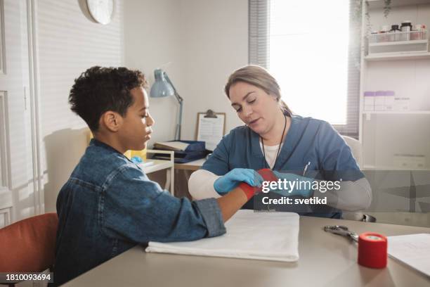 child with arm injury at doctors office - elbow bandage stock pictures, royalty-free photos & images