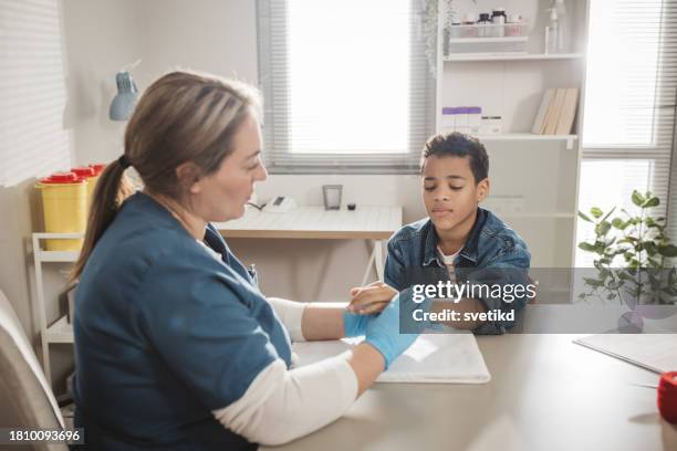 child with arm injury at doctors office - elbow bandage stock pictures, royalty-free photos & images