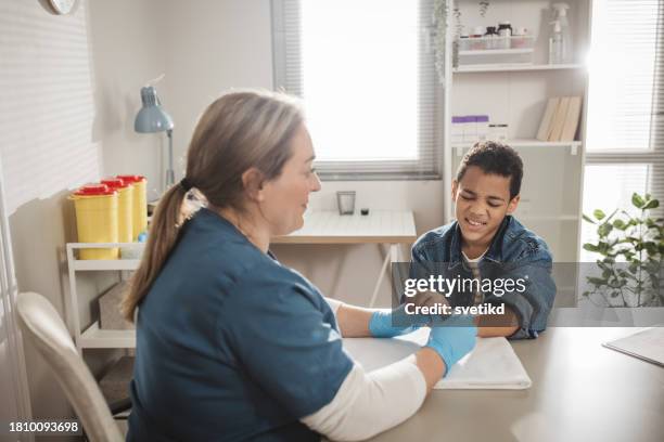 child with arm injury at doctors office - elbow bandage stock pictures, royalty-free photos & images