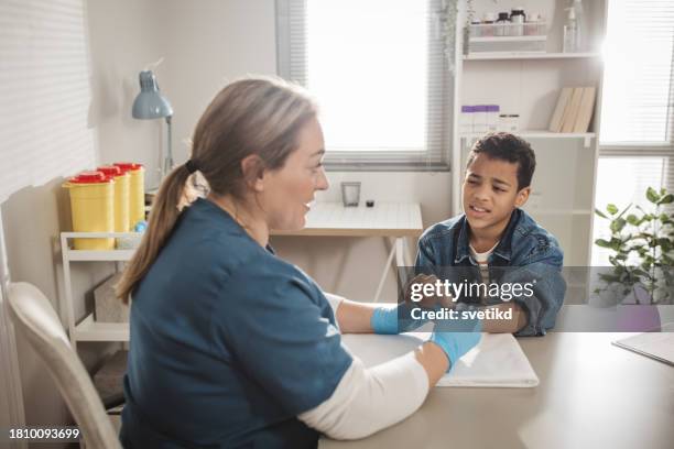 child with arm injury at doctors office - elbow bandage stock pictures, royalty-free photos & images