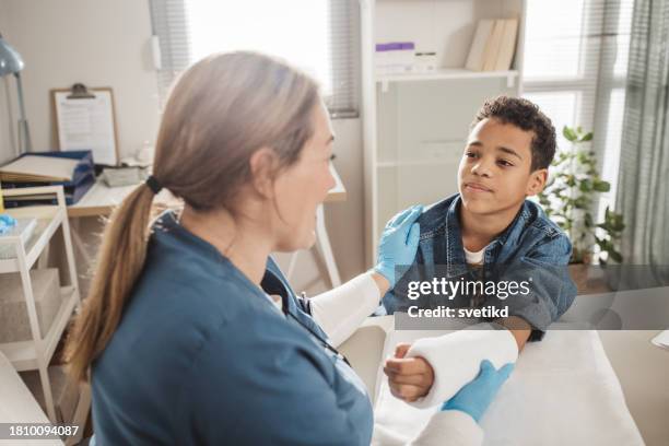 child with arm injury at doctors office - elbow bandage stock pictures, royalty-free photos & images