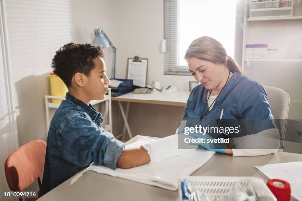 child with arm injury at doctors office - elbow bandage stock pictures, royalty-free photos & images