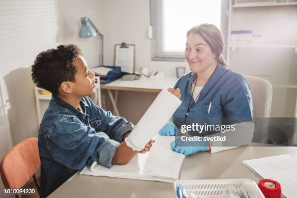 child with arm injury at doctors office - elbow bandage stock pictures, royalty-free photos & images